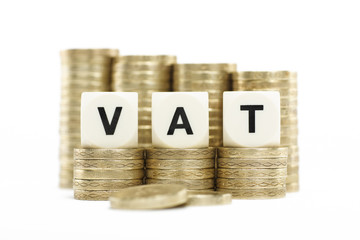 VAT (Value Added Tax) on gold coins on white background