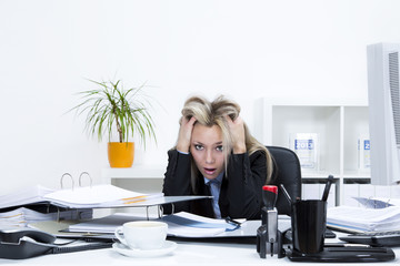 Gestresste Frau im Büro am Schreibtisch