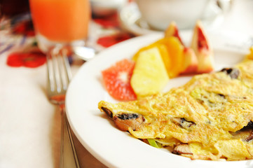 Omelet with mushrooms served with fruits - vegetarian breakfast