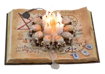 Magic book isolated with candle