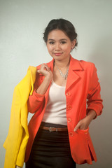 Pretty Asian business woman holding yellow suit .