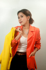 Pretty Asian business woman holding yellow suit .