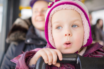 Adorable girl with mother ride on modern city bus in sunny winte © Joshhh