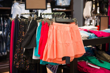 Fototapeta na wymiar Spódnice i spodnie koloru na stoisku w magazynie ubrania