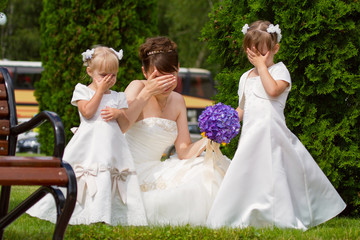 Bride stand with little girls in elegant dresses