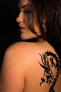 Beautiful female with tribal dragon tattoo