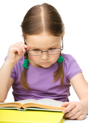 Little girl is reading a book