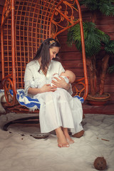 A mother with a sleeping baby in her arms in the Hawaiian interi