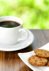 Coffee and oatmeal cookies on nature background