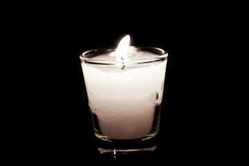 candle in glass on black background