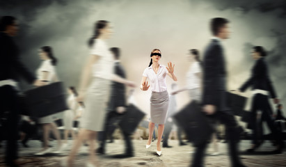 Businesswoman in blindfold among group of people