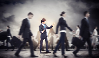 Businessman in blindfold among group of people