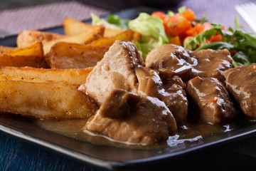 Goulash with prepared potatoes. Dark tone