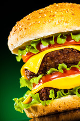 Tasty and appetizing hamburger on a darkly green