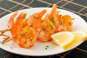 Fresh grilled shrimps with lemon on white plate
