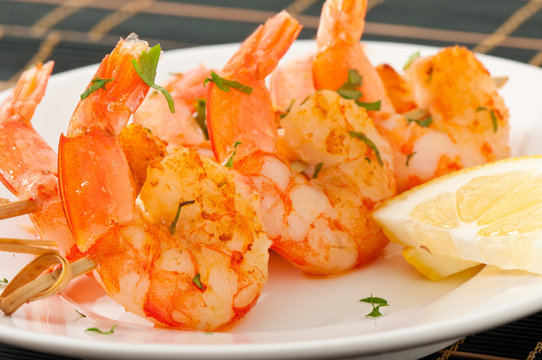 Fresh grilled shrimps with lemon on white plate