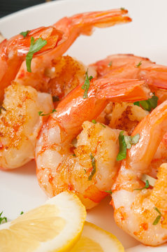 Fresh grilled shrimps with lemon on white plate