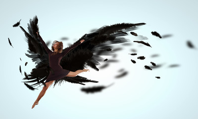 Fototapeta na wymiar Kobieta unosi się na ciemnych skrzydłach