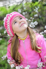 beautiful little girl near a flowering tree