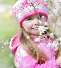 beautiful little girl near a flowering tree