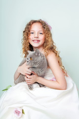 child in white dress with British cat