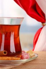 glass of Turkish tea and rahat lokum, on wooden table
