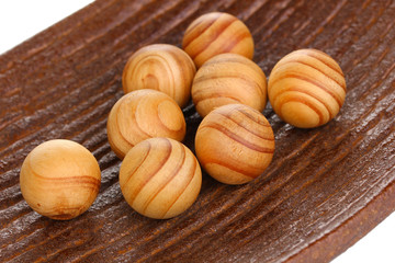 Wooden balls in decorative plate close-up.