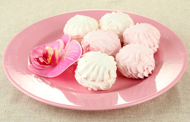 Marshmallows on color plate on light background