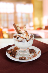 Ice cream with wafer sticks on brown napkin on room background