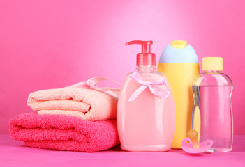 Obraz na płótnie Canvas Baby cosmetics and towels on pink background