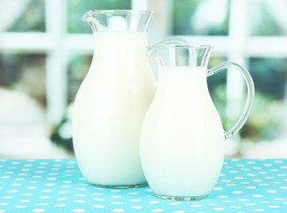 Pitchers of milk on table in room