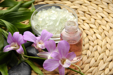 Obraz na płótnie Canvas Bowl of slat and Massage oil and pink orchid with bamboo leaves 