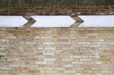 Brick wall with arrows signs