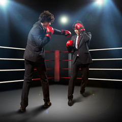 Two young businessman boxing