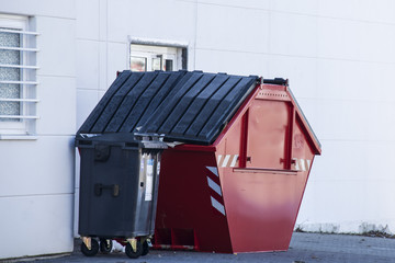 roter Müllcontainer und schwarzer Mülleimer