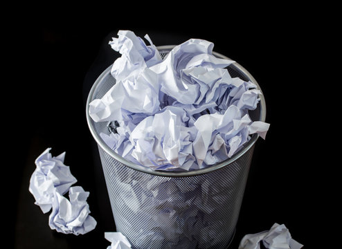 Recycle bin filled with crumpled papers