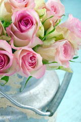 Bouquet of pink roses in a rustic bucket