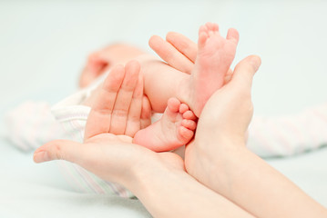 little baby feet and hands of the mother