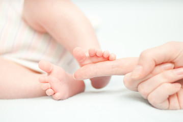 little baby feet and hand of the mother