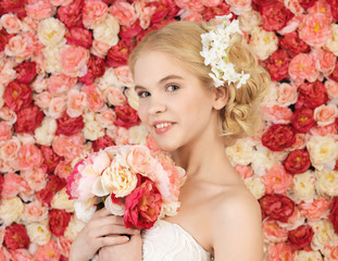 woman with bouquet and background full of roses