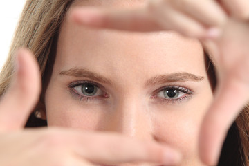 Fototapeta premium Beautiful woman framing her blue eyes with the fingers