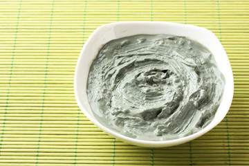 Cosmetic clay for spa treatments, on bamboo background