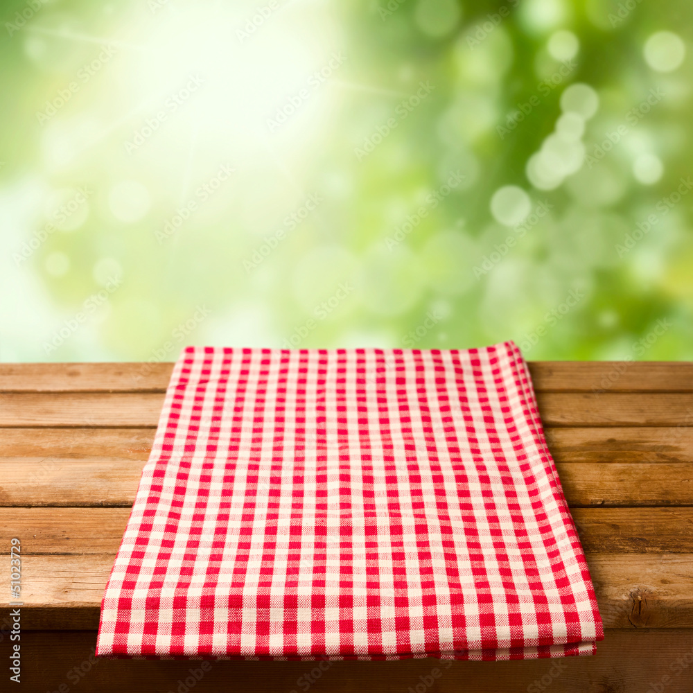 Poster Empty wooden table with tablecloth over bokeh background