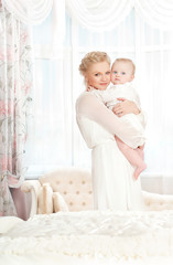 young mother with a baby in a beautiful bedroom