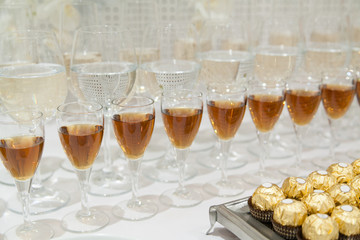 Closeup of row of filled drink glasses with chocolate candies