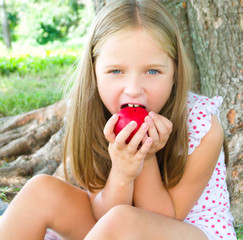 Portrait of a little girl eating apple