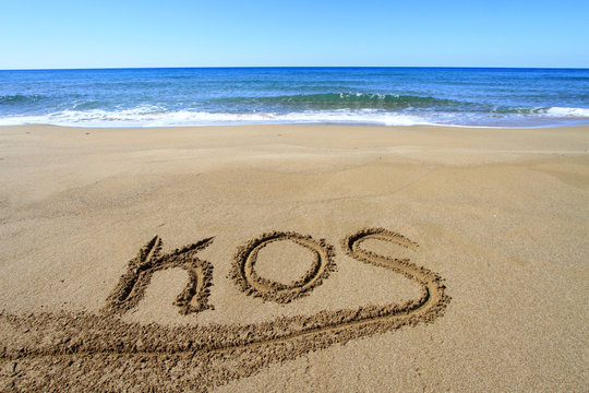 Kos written on sandy beach