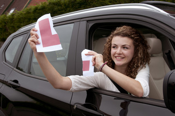 Young female driver holding L learner plate