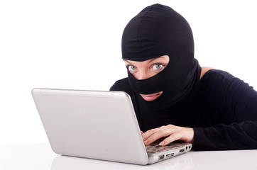 Hacker with computer wearing balaclava