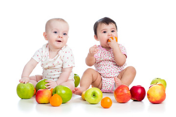 Funny kids babies eating healthy food fruits isolated on white © Oksana Kuzmina